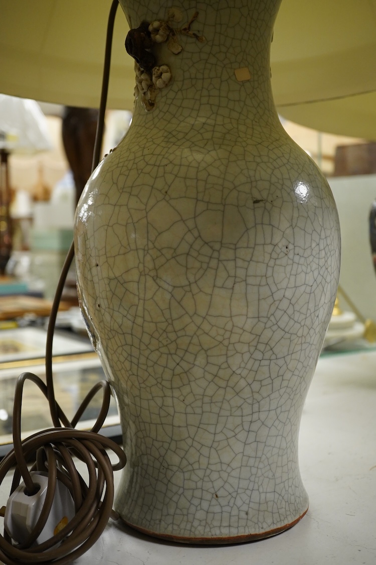 A large pair of early 20th century Chinese crackle glaze vases, mounted as table lamps, eac decorated in relief with peacocks, overall 80cm high